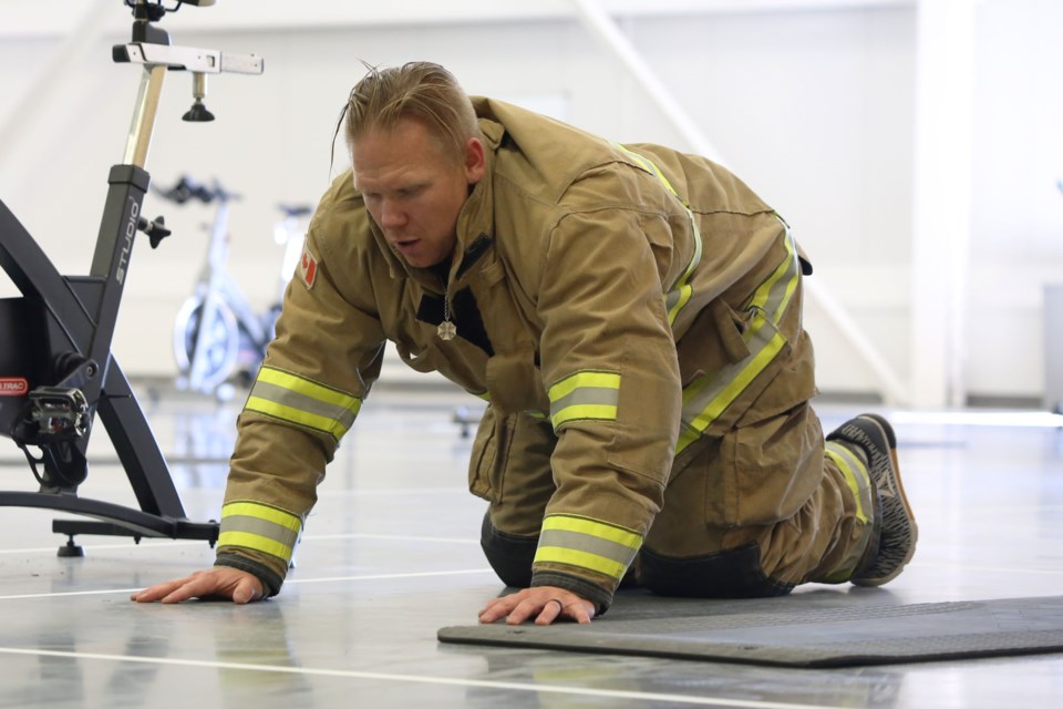 Jeremie Huolt, the founder of the 9/11 memorial workout, pauses for a breath between sets of pushups. Huolt said at the start of the event to remember the purpose of the workout. Every one of the 412 exercises performed was to honour one of the fallen emergency personnel who gave their life on 9/11. (Tyler Klinkhammer/The Cochrane Eagle).