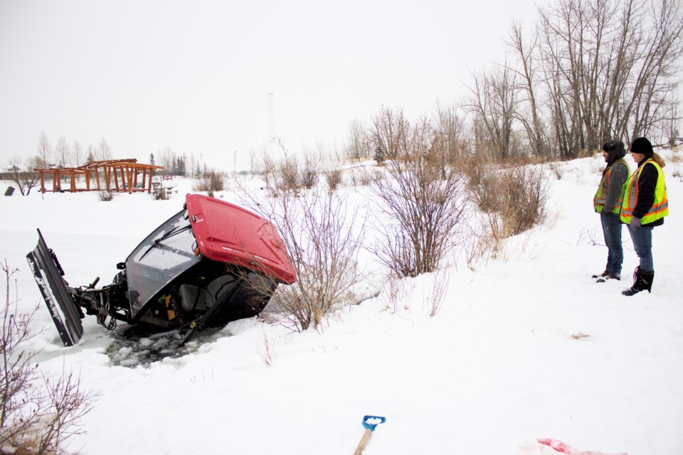 An outdoor ice resurfacing machine is partially submerged after it broke through the ice at Mitford Pond after 10 a.m. Friday. Photo by Cathi Arola