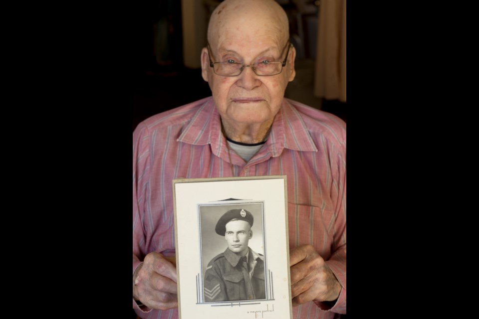 Ray Stewart holds a photo of himself.