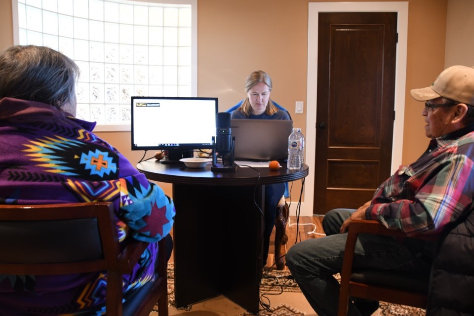 Elders Una Wesley, left, and Henry Halloway, right, work with Doro Hoffman, a scribe involved with the Stoney language project. (Photo Submitted/Cherith Mark)