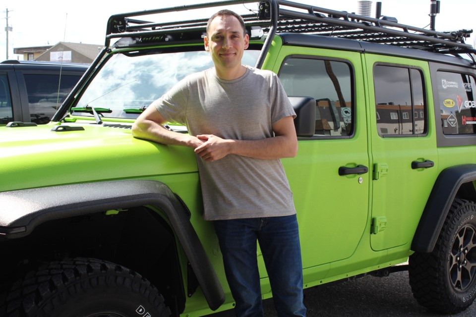 Cochrane's Braydon Moriseau with the especially equipped Preda-Tor vehicle he uses for storm chasing.