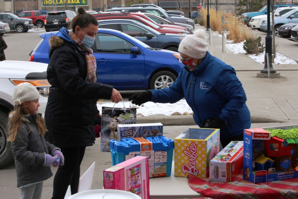 Cochranite Jakki MacKenzie and her daughter Danielle Shillington drop off a gift for the Stuff a Bud event on Saturday (Dec. 12) afternoon. (Tyler Klinkhammer/The Cochrane Eagle)