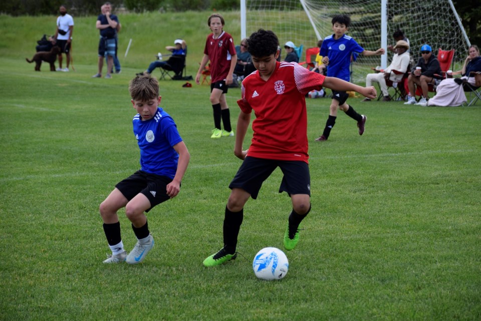 Cochrane Wolves players (red) battling against teams from Calgary at Rangers Field on June 28. 