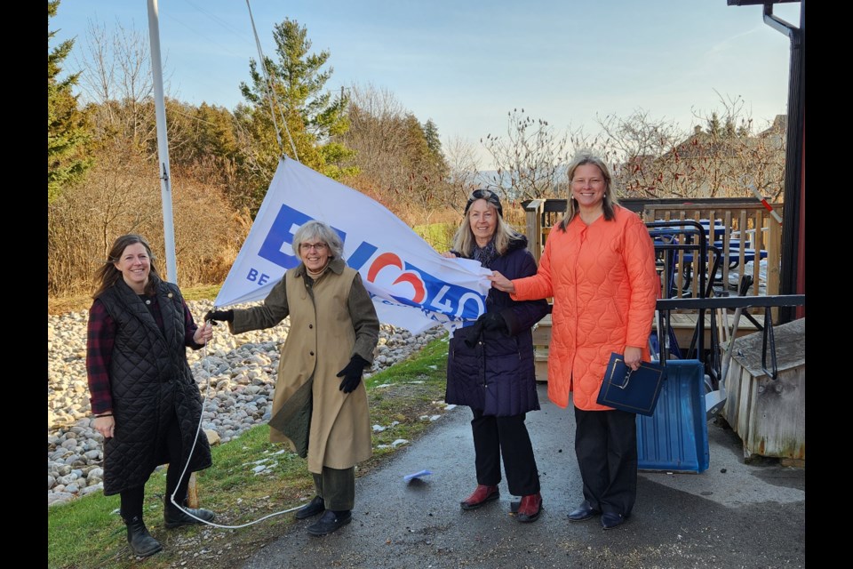 Beaver Valley Outreach lowered its 40th anniversary celebration flag at a special event on Dec. 15. From left: Carolyn Letourneau, Norine Baron, Cathy Innes and Mayor Andrea Matrosovs.