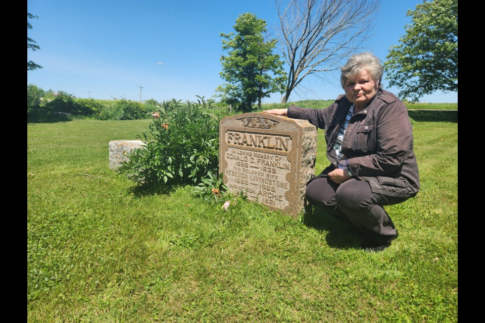 Elizabeth Marshall with the headstone of her grandparents at Gibraltar Presbyterian Cemetery in The Blue Mountains.