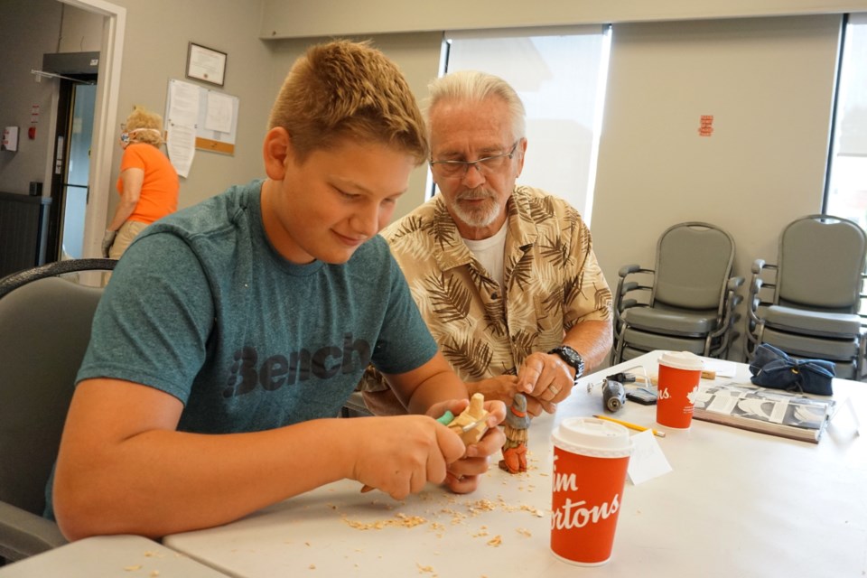 Tom Sudak gives his visiting grandson, Taylor, whittling advice during this week's meeting of the Collingwood Chippers.
