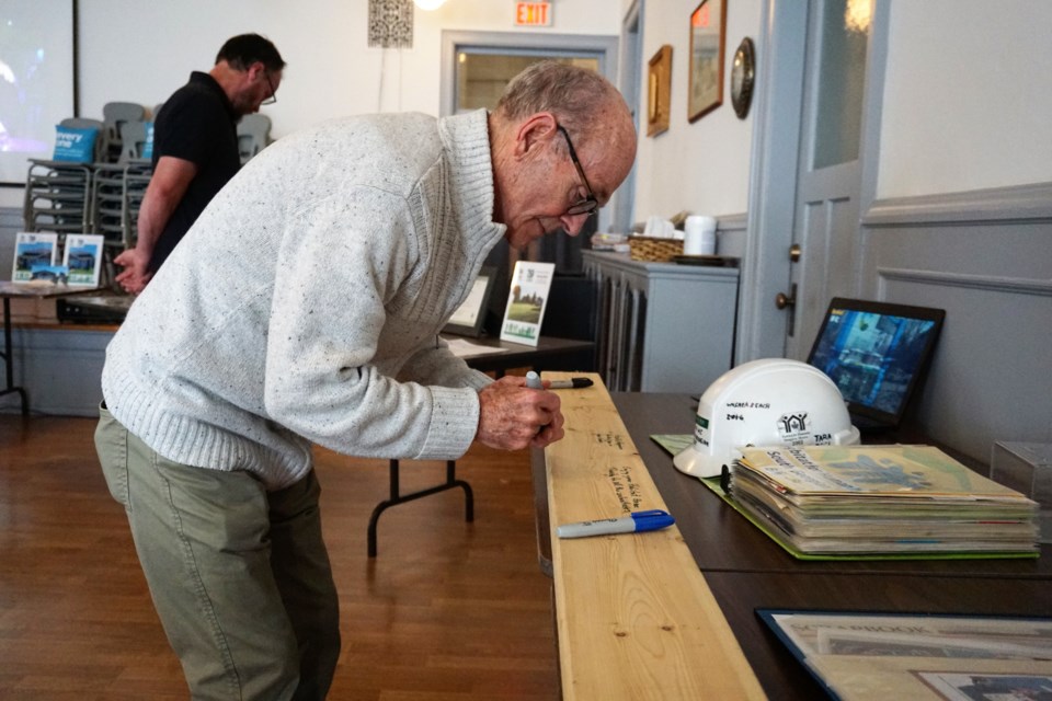 Garry Reid signs a 2x4 at the Habitat for Humanity South Georgian Bay 20th anniversary event at Trinity United Church in Collingwood on June 22, 2022.