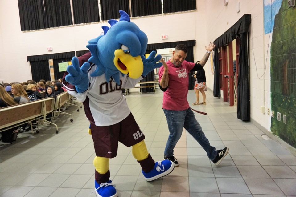 Teacher Jonathan Resendez (right) dances with Harry the Hurricane, the Our Lady of the Bay mascot during Grade 9 orientation day on Aug. 31, 2023.