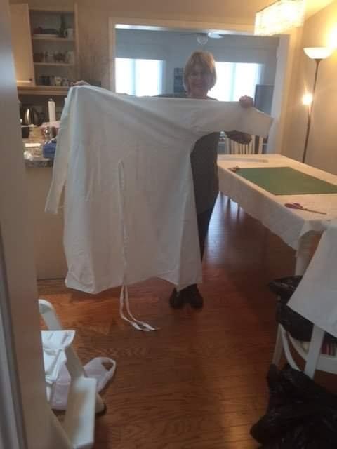 Bev Noddle shows off a completed reusable surgical gown like the 300 others sewn for Collingwood General and Marine Hospital by volunteers in the community. Contributed photo