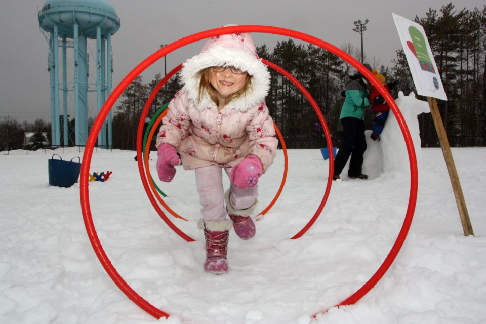 Pheobe runs through a hoop tunnel at Central Park where town staff have set up an outdoor playground and activity centre for families as part of the Art of Winter festival. Jan. 25, 2020. Erika Engel/CollingwoodToday