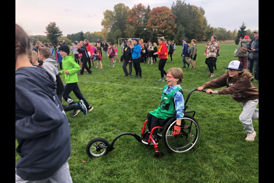 Charlie Damianov gets a little help across the grassy field at the start of the cross-country race. 