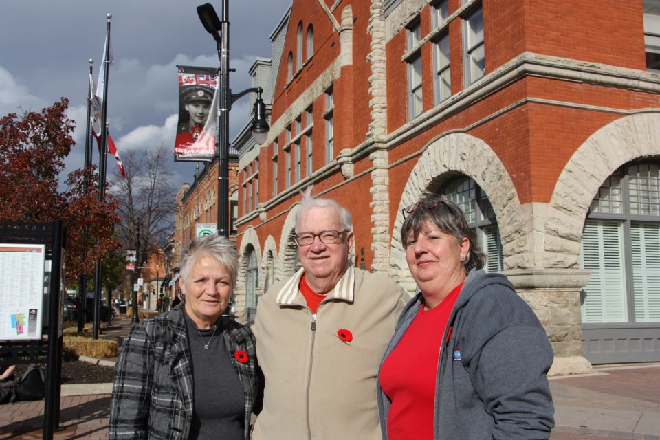 Susan Nicholson, General Manager of the Downtown Collingwood BIA; Don Wilcox, chairperson of the Collingwood Legion Branch 63 museuml; and Penny Skelton, chairperson of the Collingwood Downtown BIA Board of Directors, stand in front of one of the commemorative banners installed last year as a tribute to veterans. Erika Engel/CollingwoodToday