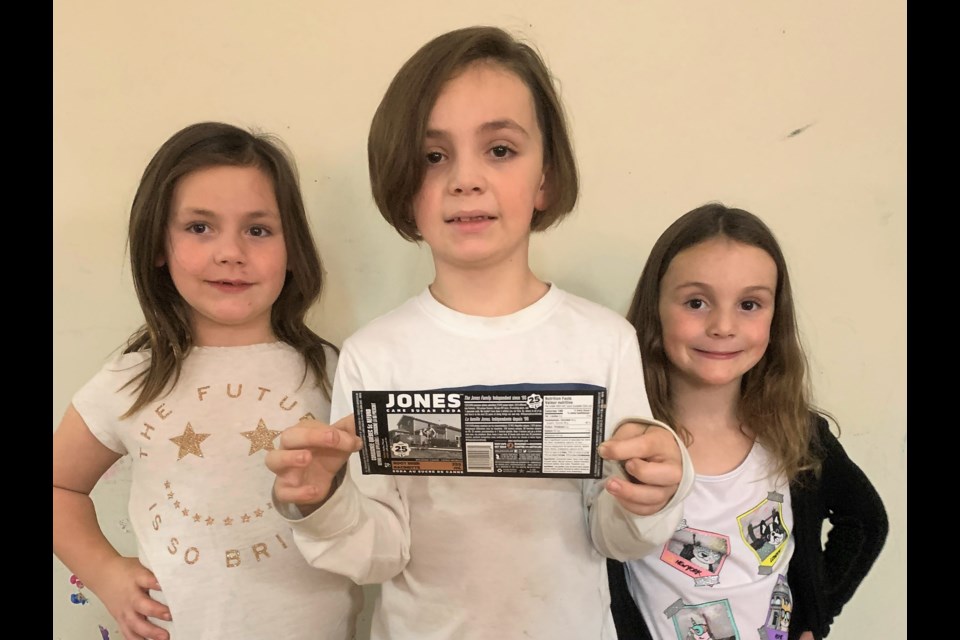 Seven-year-old Scarlett, Ben (8) and Piper (5) holding the Jones Soda label with their winning photo.