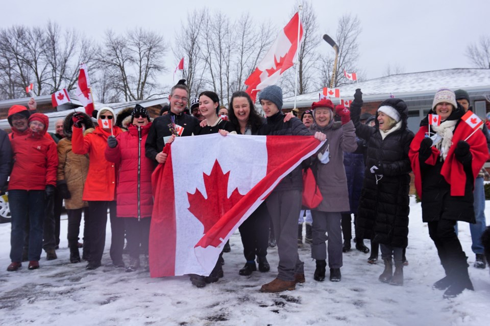 The Michael family (holding the flag, from left, Douglas, Rebecca, Vanessa and Jason) celebrate becoming Canadian citizens on Wednesday along with members of All Saints Anglican Church. 