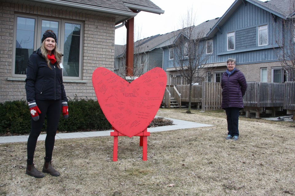Cathy Bawden and Dianne Steele stand by the heart-shaped tribute the neighbourhood put together as a surprise for Bawden when she got home from work. Erika Engel/CollingwoodToday