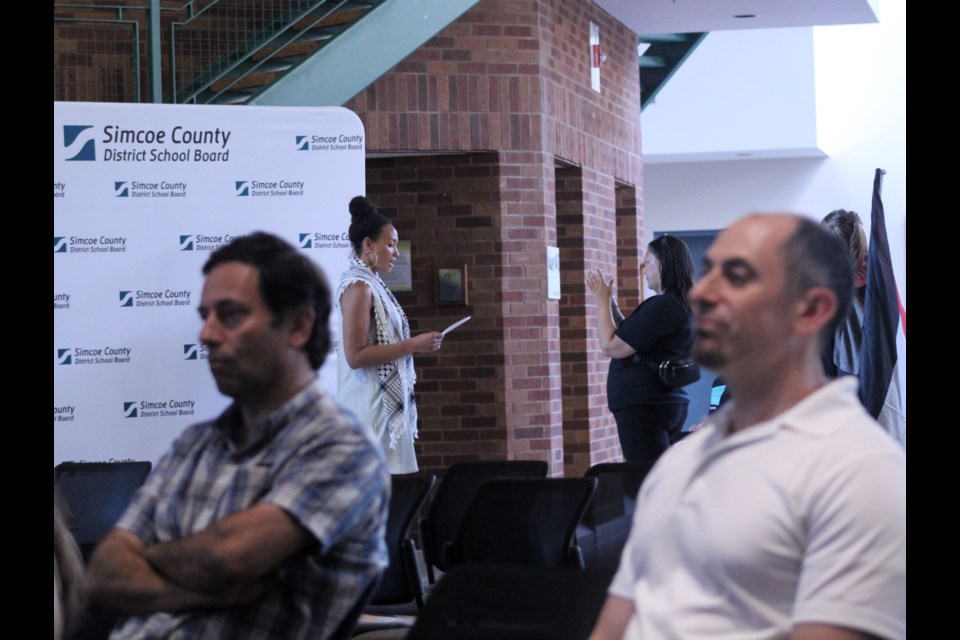 Natasha Shakespeare, founder of Parents Against Racism Simcoe County (centre), performs a delegation in the hallway of the Simcoe County District School Board administration centre in Midhurst, following the board denying her request for an in-person delegation during the meeting.