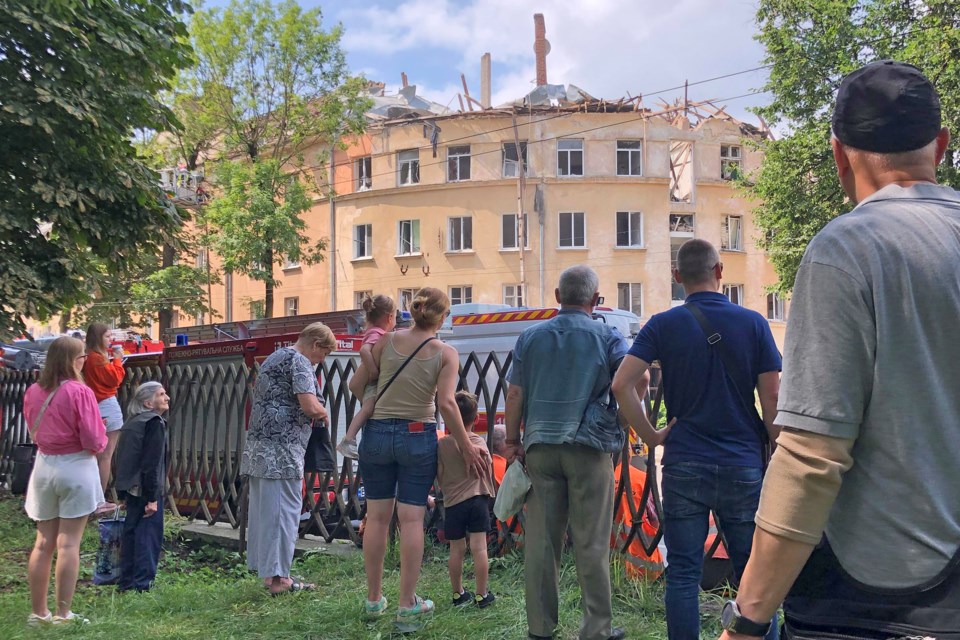 Onlookers watch rescue work at an apartment building in the city of Lviv, Ukraine, the morning after a Russian missile strike.