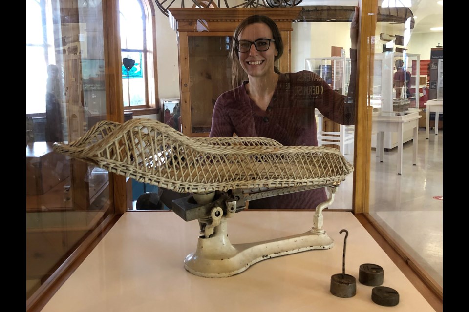 Elise Barr-Klouman poses at the Collingwood Museum with a baby scale used by Nurse Ethel May Dawson, which is currently on display.