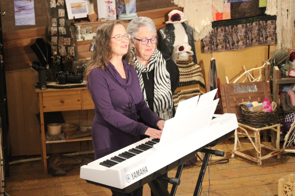 Author Sharon Krushel with good friend and fellow artist Mary Parslow, singing a song together at the opening reception for the 'Mother Earth' exhibit at the DC Art Gallery. 

In addition to her photography, Krushel is also a trained musician and professional voice coach. 