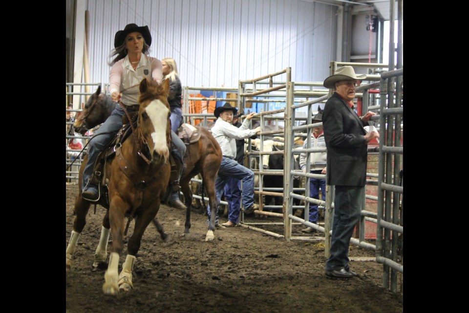 Warburg, Alberta's Keely Anne Steinman hits the ladies barrel race as Pouce's Clayton Moore and Canadian Pro Rodeo president Terry Cooke look on.