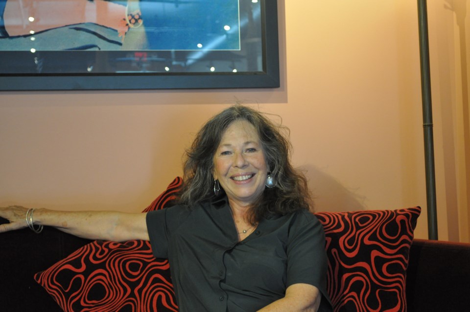 Carol Miles sitting on red couch