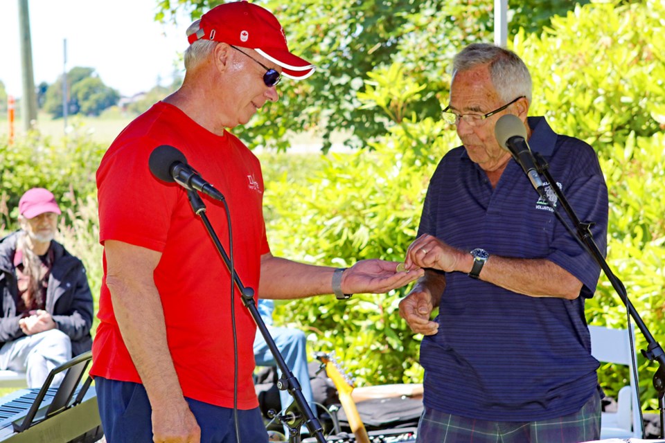 Kirkland House Society president Colin Campbell presents the annual rent - a Toonie to Delta Mayor George Harvie as part of the opening ceremonies at the Kirkland House Canada Day celebration in Ladner.