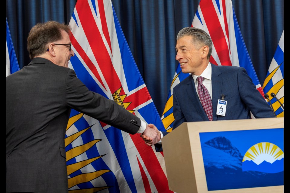 BC Health Minister Adrian Dix shakes hands with Dan Levitt, who was announced as the new seniors advocate for British Columbia, at the B.C. legislature press theatre in Victoria on Jan. 26. 
