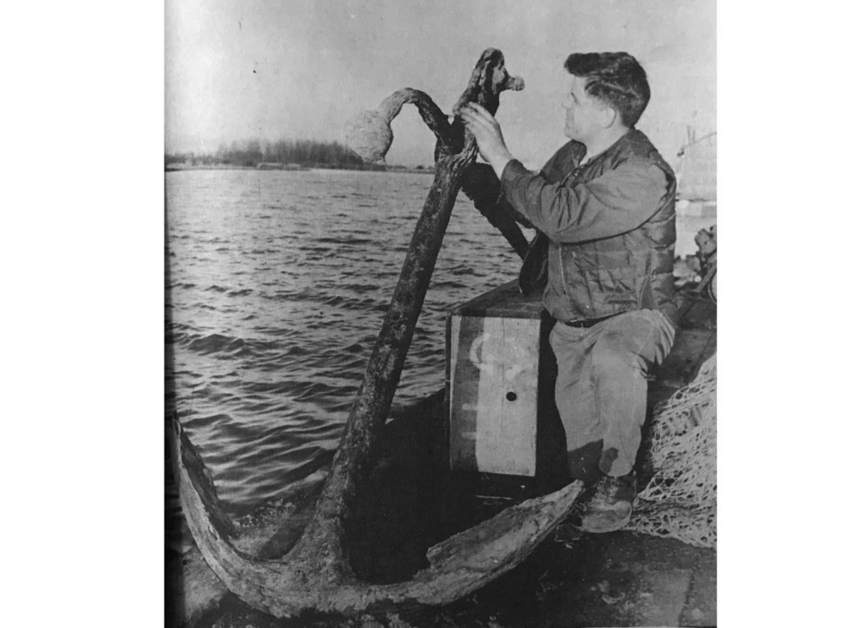 1969 photo of doug massey checking out a century-old anchor discovered