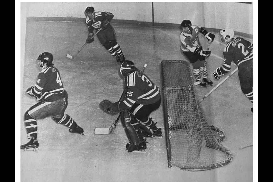 Ladner Fishermen goalie Peter Guichon was again the ‘stronghold’ in in the second game of their 1975 playoff final series against the CP Air Seagulls. The Seagulls stretched their lead in the series to 2-0 games with a double-overtime victory at the South Delta Rec Centre for the Vic Fisher Cup. Also pictured is Ladner’s Ken Bates (4) Bun Harris (12) and Pat Begley (2), while Tom Aquiline of the Seagulls was in the offensive zone.