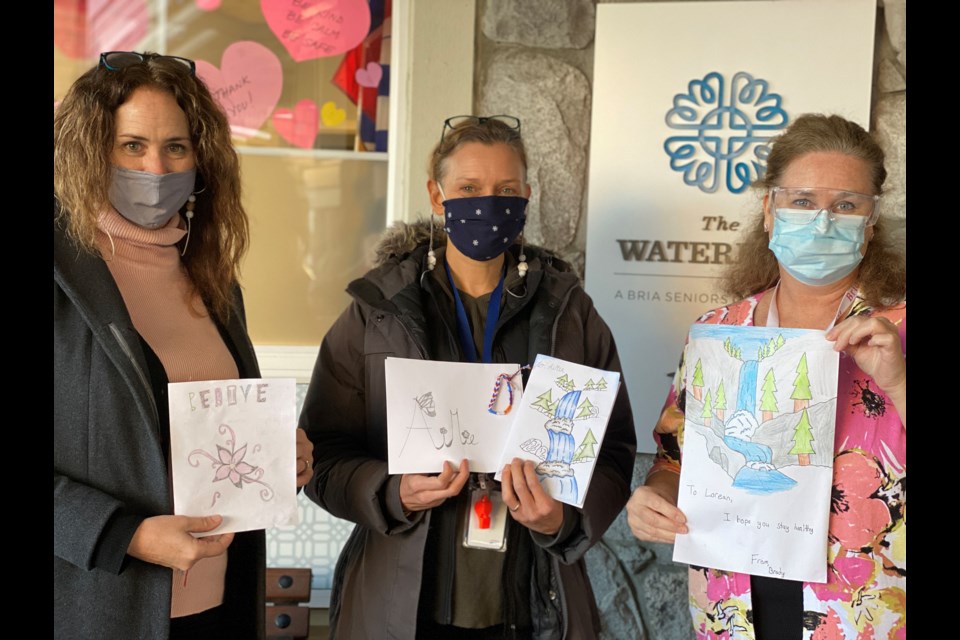 Teachers  Joanne Calder and Nancy Klassen representing Beach Grove Elementary and Brenda Hodson, Recreation Director at The Waterford show off some of the cards students wrote to seniors.