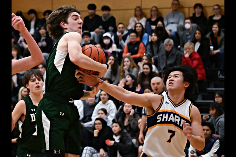 Delta's Macin MacDonald soars for the rebound as a capacity crowd at Steveston-London on Friday night looks on. 