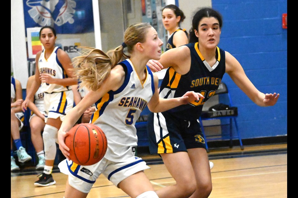 Seaquam Grade 9 standout Callie Brost is defended by Kyra Millette during Wednesday's South Fraser AAAA Senior Girls Basketball League game. Brost had 21 points as the host Seahawks won 65-44.