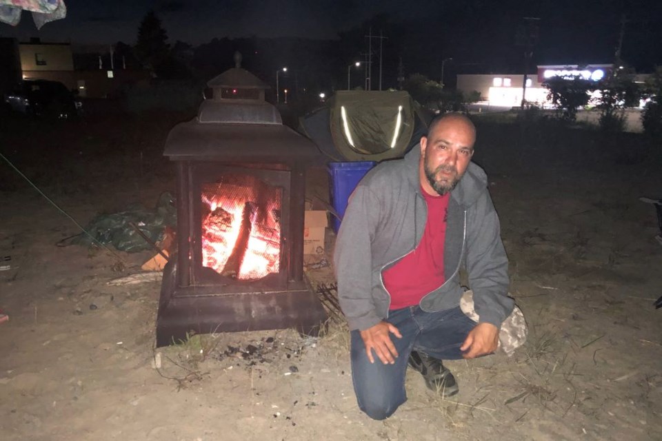 Mayor Dan Marchisella stays warm near the fire.