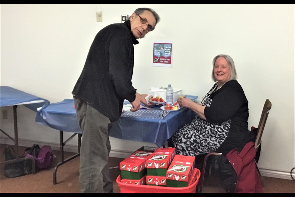 Roger Legacy and Lynn Legacy prepare shoeboxes for Christmas Child.