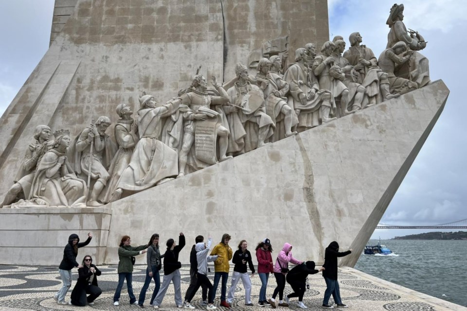 Students pose for a photo in front of the Monument of Discoveries.