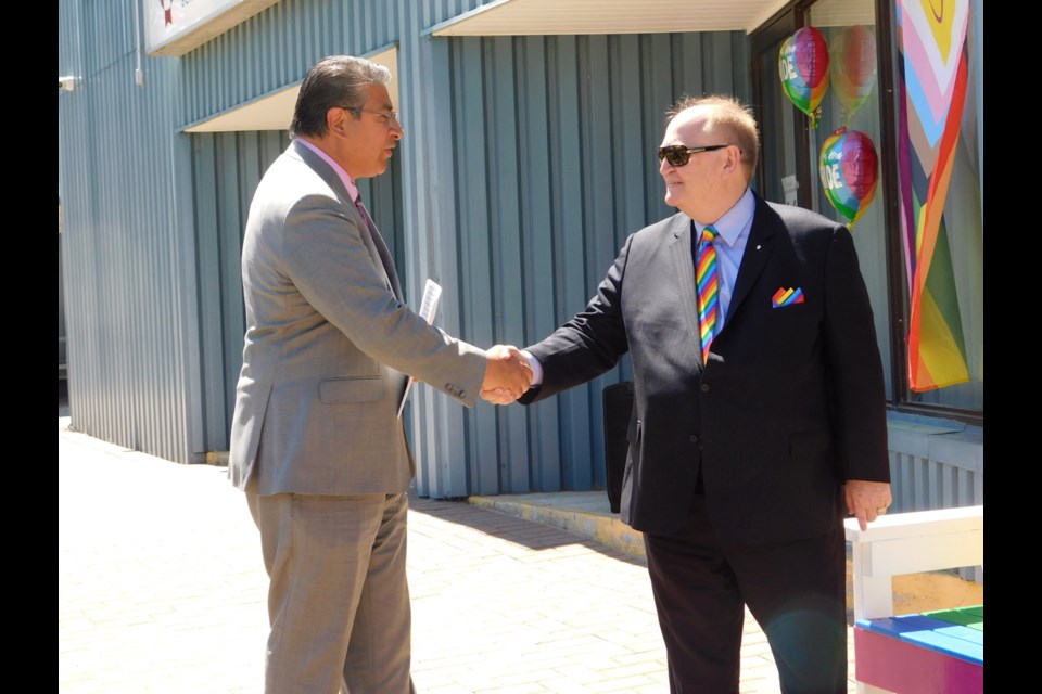 Douglas Elliott (right) is congratulated by Ali Juma AFS CEO for his work in the Pride community.