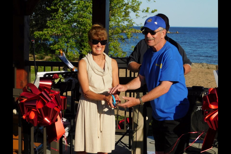 Blind River mayor Sally Hagman assists Ross Jensen cut the ribbon for the official dedication of the Bea Jensen Pavilion early Thursday evening.