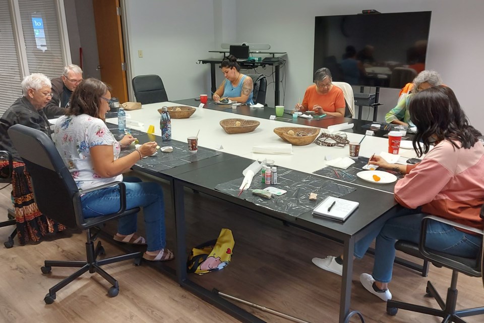 Participants in the Indigenous Friendship Centre’s Social Hour use their artistic skills to paint rocks with decorative motifs or sayings. From left, Coreen Kane, Paulette Woolhead, Ron Woolhead, Cindy Mahoney, Louise Poitras, Judy Lewis and Jennie Therrien.