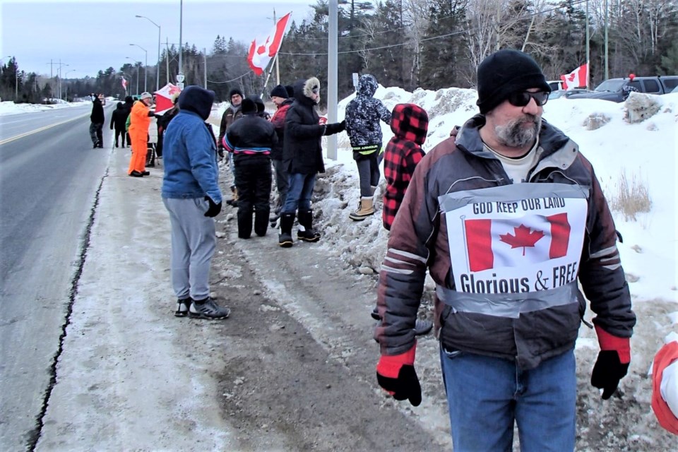 A group from Elliot Lake line the Trans-Canada Highway at the Highway 108 junction on Saturday.