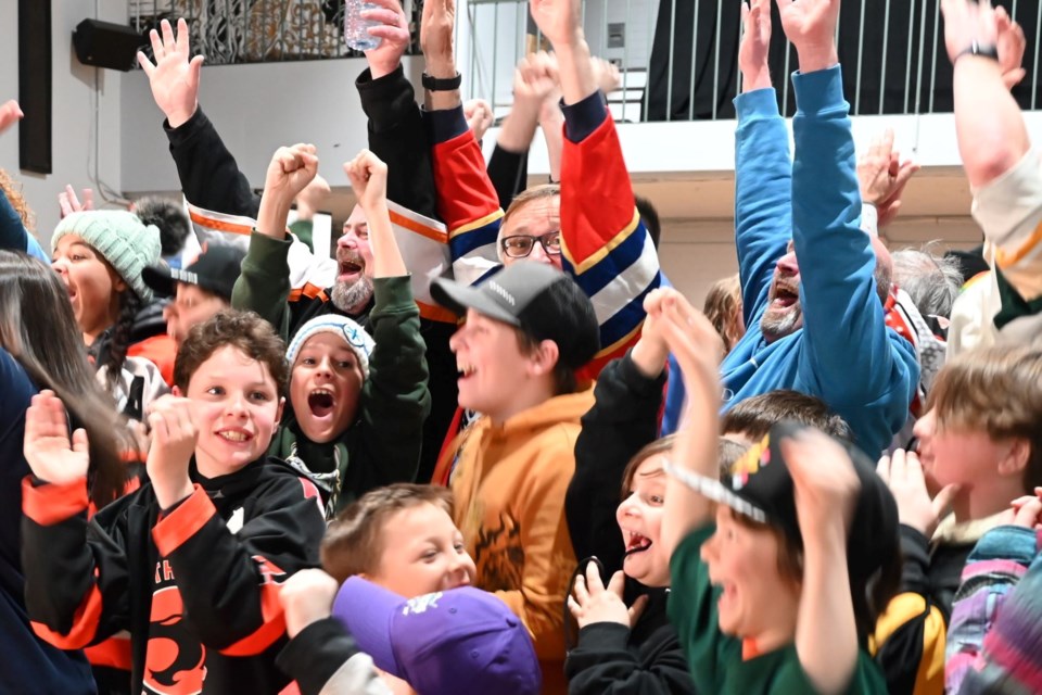 At the moment of announcement. Mayor Andrew Wannan, Coun. Charles Flintoff, and Coun. Merrill Seidel raise their arms in celebration surrounded by young Elliot Lakers cheering the news of the $250,000 win. Mar. 30, 2024
