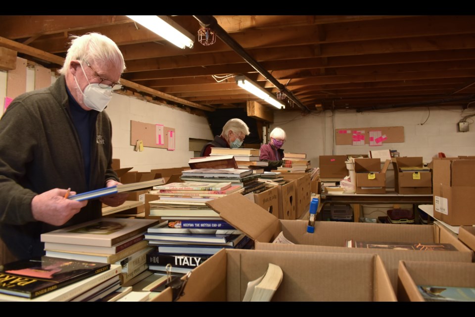 Volunteers sort items and discard what isn't usable to prepare for May's fundraiser. 