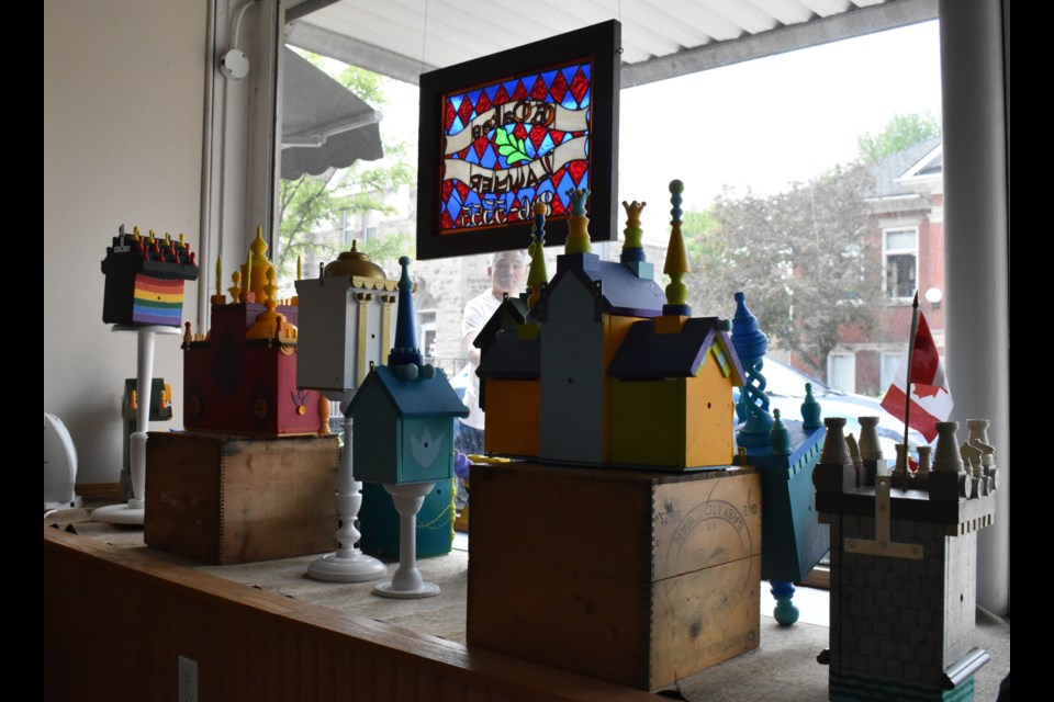 Graeme Chalmers' upcycled birdhouses at seen inside Greg Oakes' law office. Oakes said he's never seen so many children interested in the art in his window than he has with this piece.