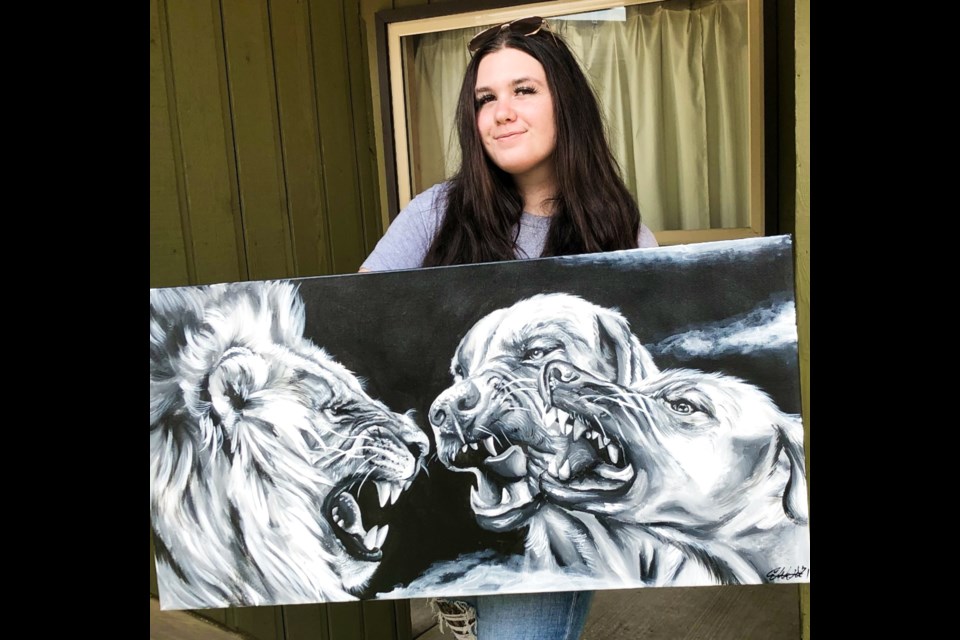 Emily Walser with a custom painting of dogs and a lion.