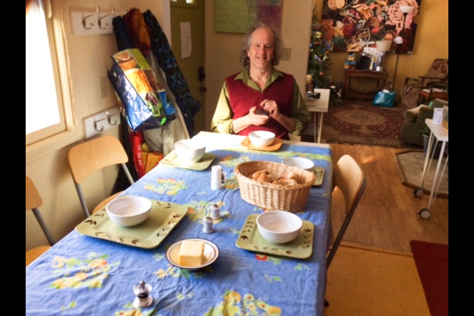 Peter Skoggard sits at the end of a table while preparing a meal for a previous Bungalow Community Lunch event.