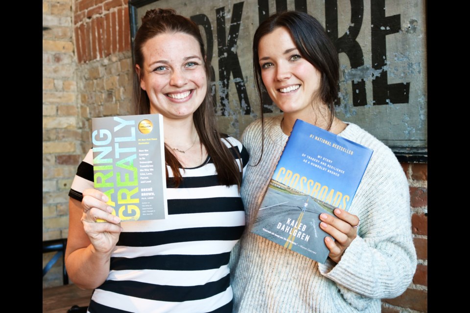 Rebecca Clement, left, and Jaylyn Leighton hold up two books they have read as part of their book club, 'Book Babes of CW.'