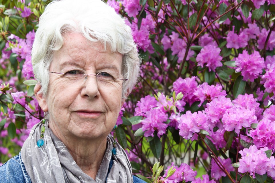 Jean Loney with purple flowers in the background.