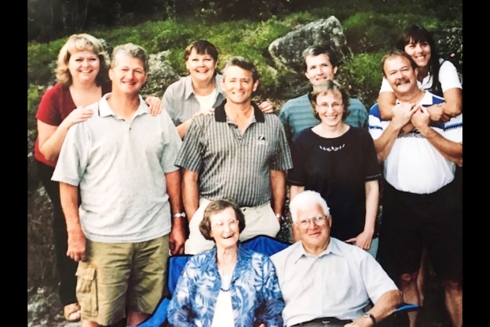 Norma Harrop, centre left in a blue jacket, posing for a family photo.