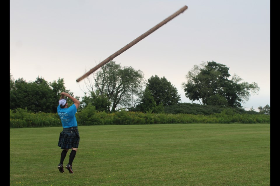 Jamie Trask demonstrated how to successfully toss a caber during a press event.