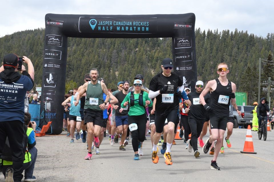 Runners take off from the starting line of the Jasper Canadian Rockies Half Marathon on Saturday, April 27, 2024. The route began at the RV parking lot near Home Hardware and crossed the highway to loop around Old Fort Point Road. | Peter Shokeir / Jasper Fitzhugh