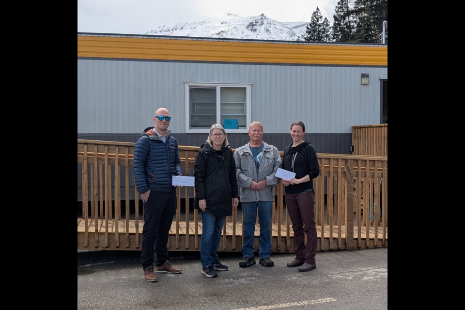 Susan and Derek Roy with the Caring Collective present cheques to the Jasper Food Bank and the Jasper Community Team Society on Thursday, May 8, 2025.